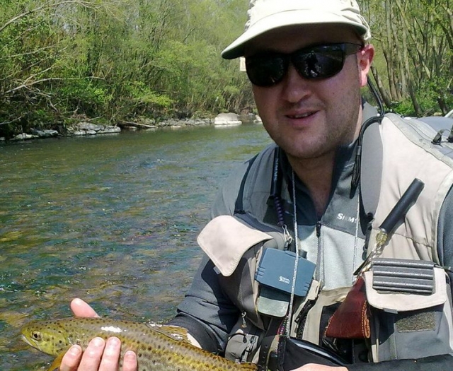 hombre ensenando un pez que ha pescado